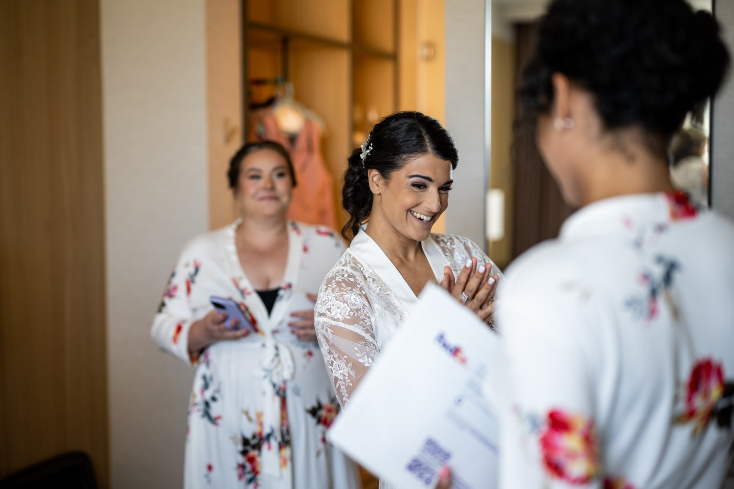 Bride getting ready with bridesmaids in floral robes at AC Hotel San Rafael before Stonetree Estate wedding