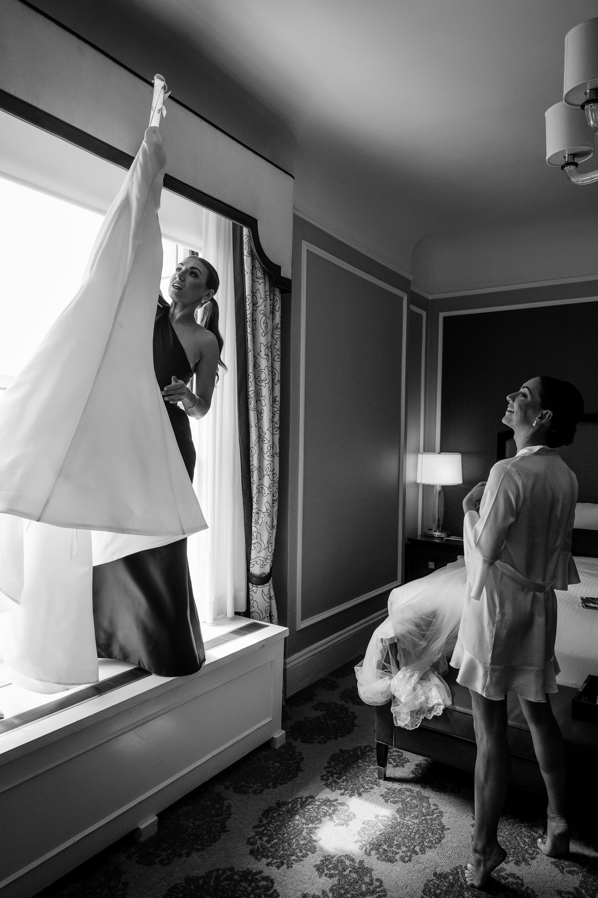Bridesmaid grabbing the wedding dress for the bride. Photo by San Francisco Wedding Photographer Duy Ho