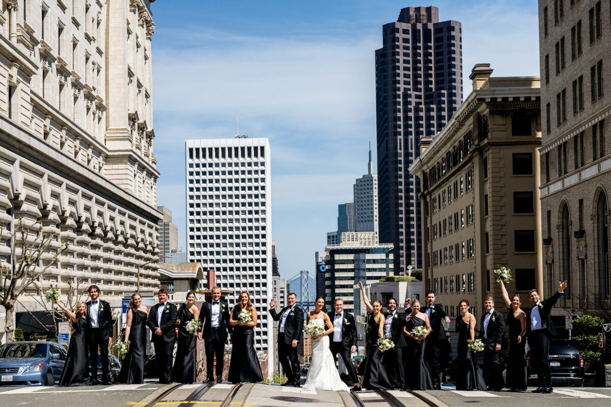 Casual group photo of a large wedding party crossing California Street in Nob Hill. Photo by San Francisco Wedding Photographer Duy Ho
