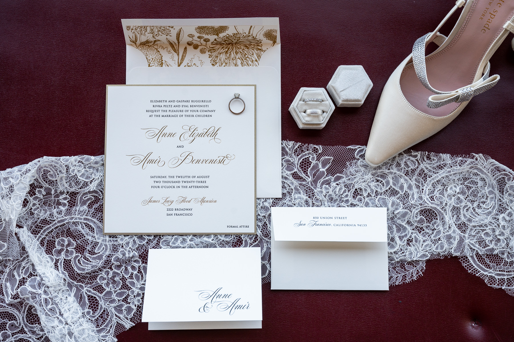 Wedding invitation suite with calligraphy, diamond ring box, and silver heels on burgundy lace, Flood Mansion wedding detail