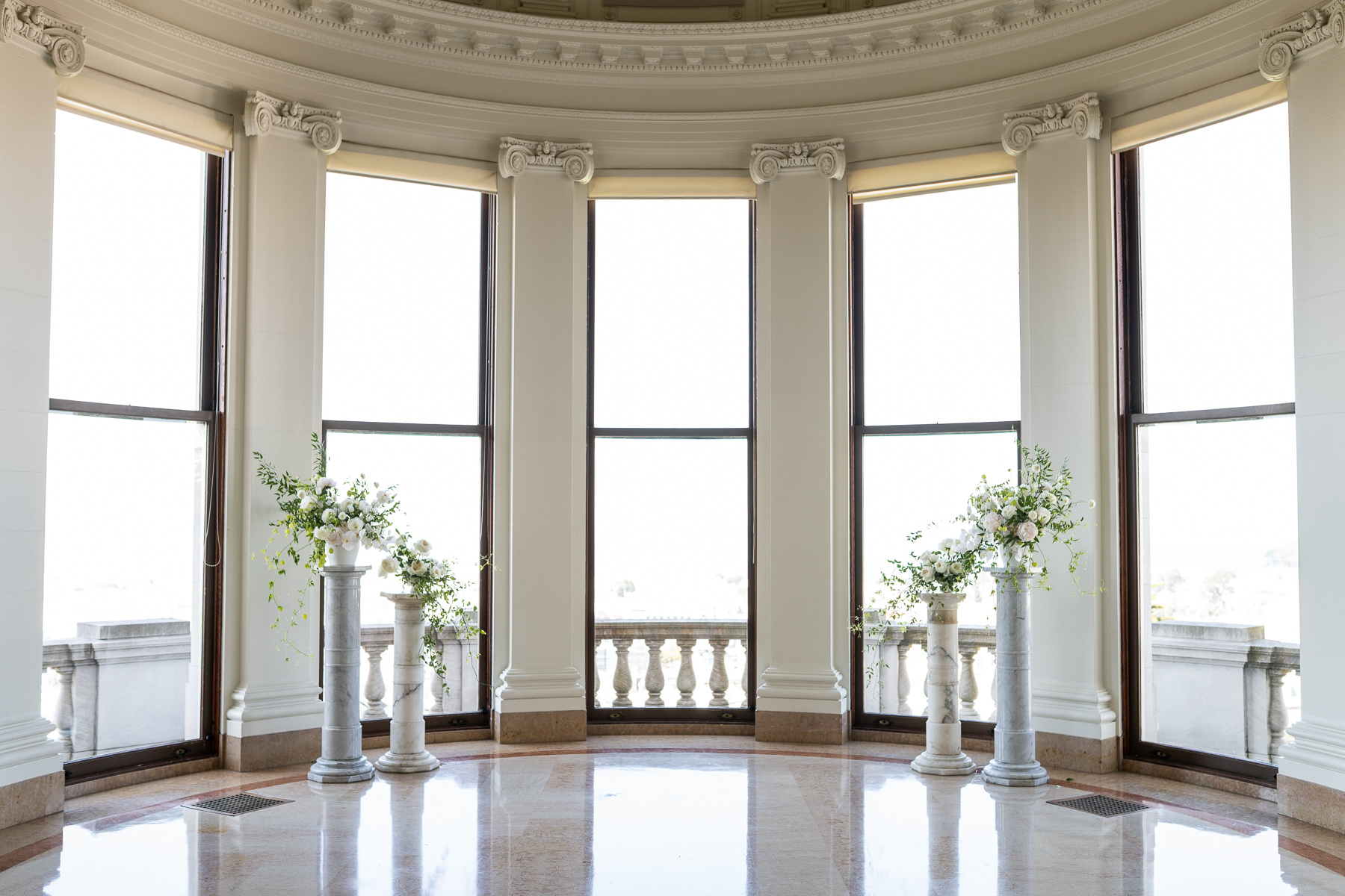 Empty Grand Hall bay window alcove at Flood Mansion set for ceremony with floral columns and natural light