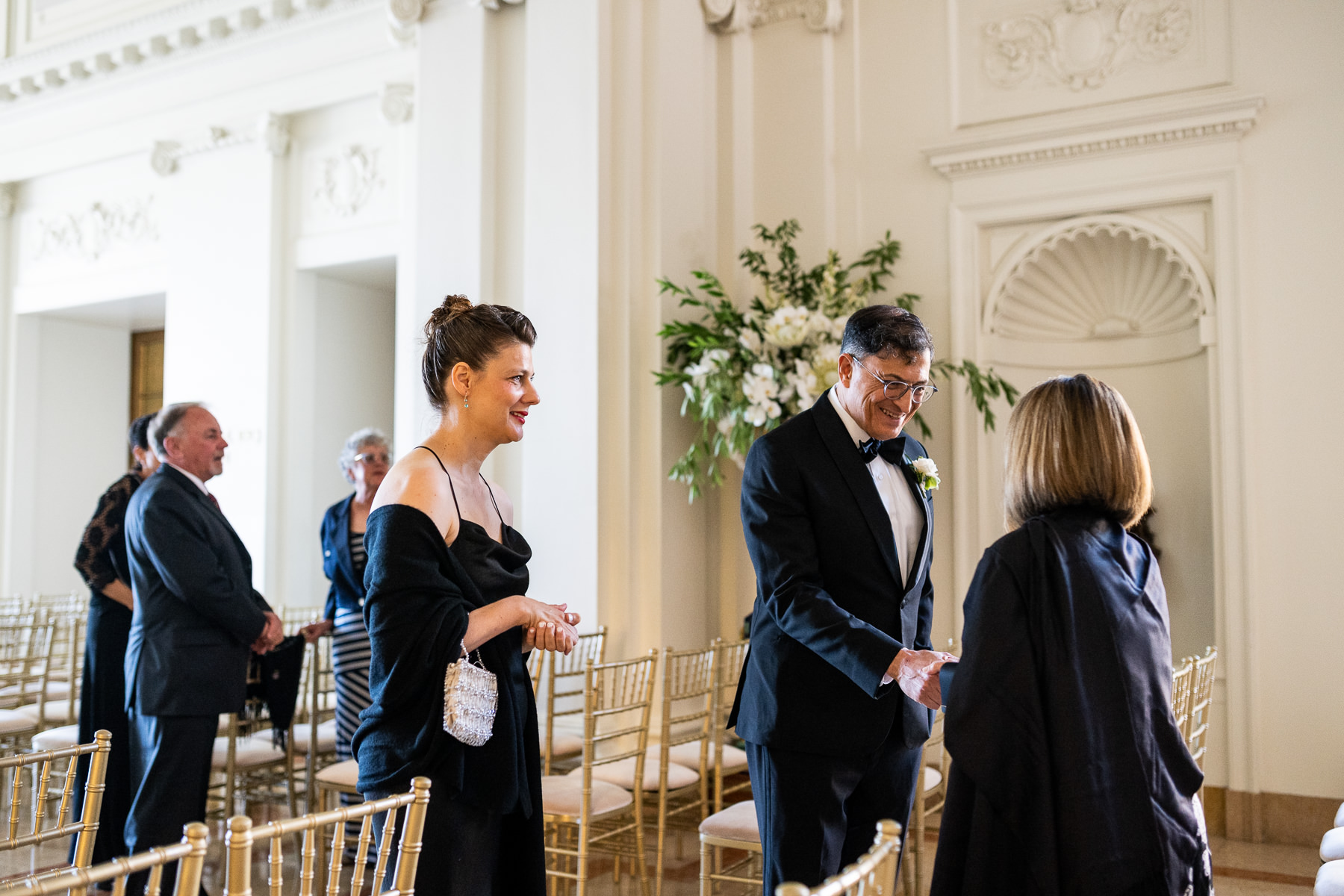 Groom greeting guests and family before ceremony in Flood Mansion Grand Hall, San Francisco mansion wedding