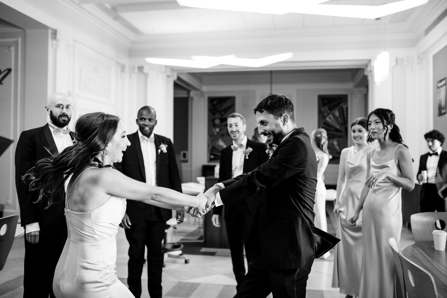 Black and white photo of guests being seated in Grand Hall for ceremony, groom waiting at altar, Flood Mansion San Francisco