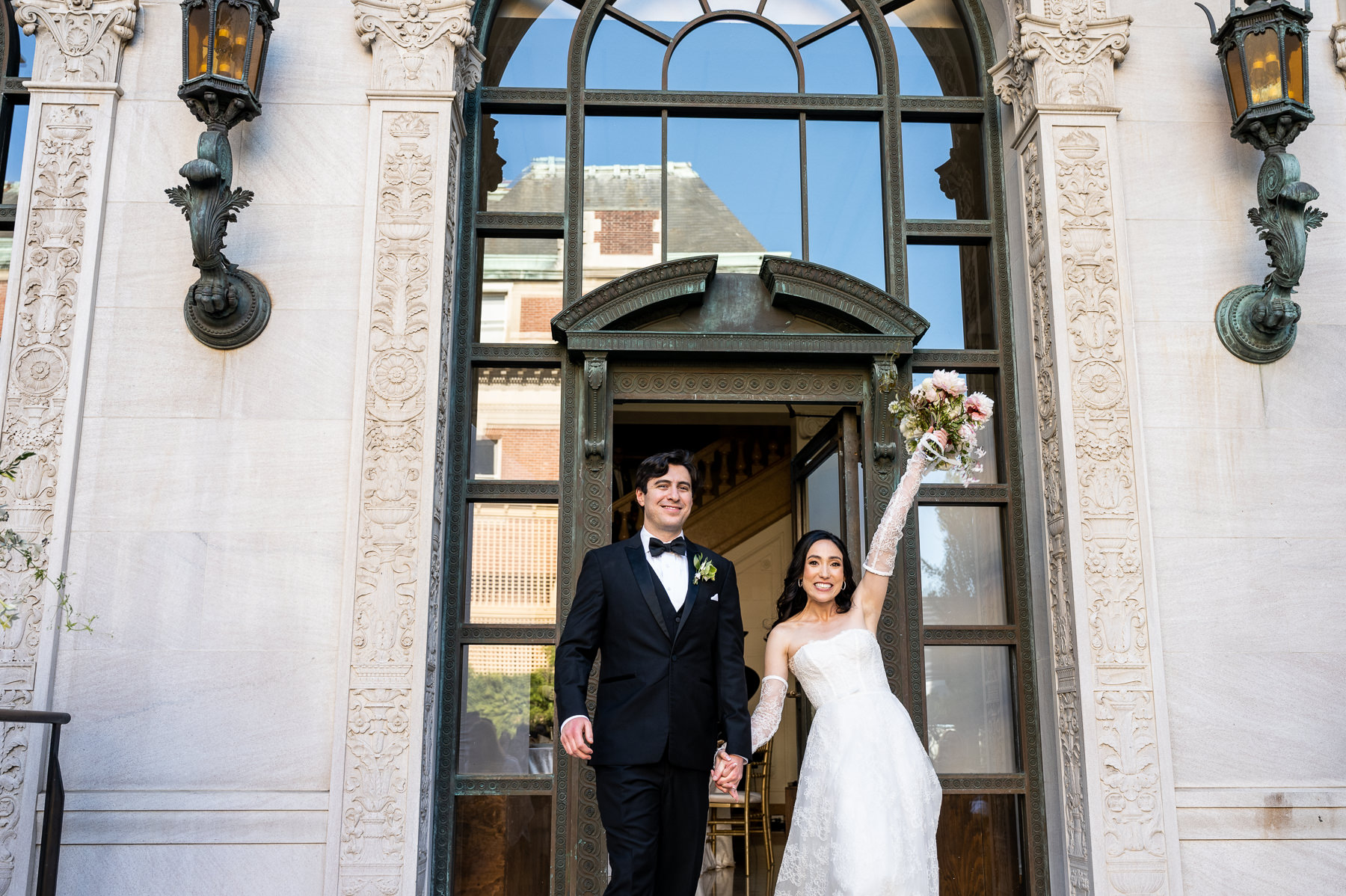 Couple portrait standing in Flood Mansion arched entrance doorway, bride in lace gown and groom in tuxedo