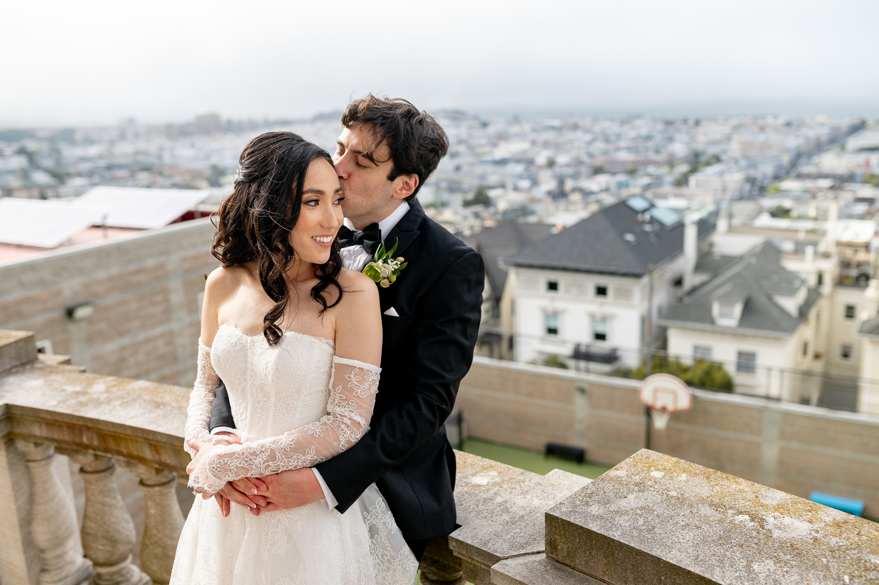 Couple portrait on Flood Mansion rooftop balcony with Pacific Heights neighborhood rooftops in background