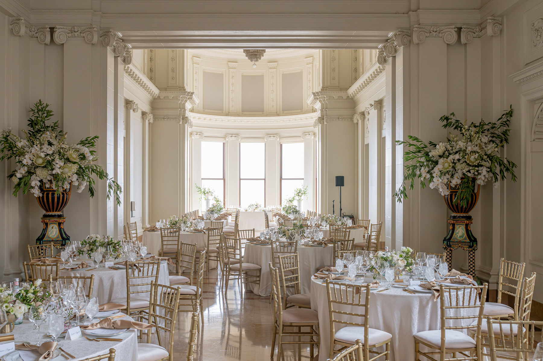 Long reception dinner table with white florals and gold settings in Flood Mansion, San Francisco mansion wedding