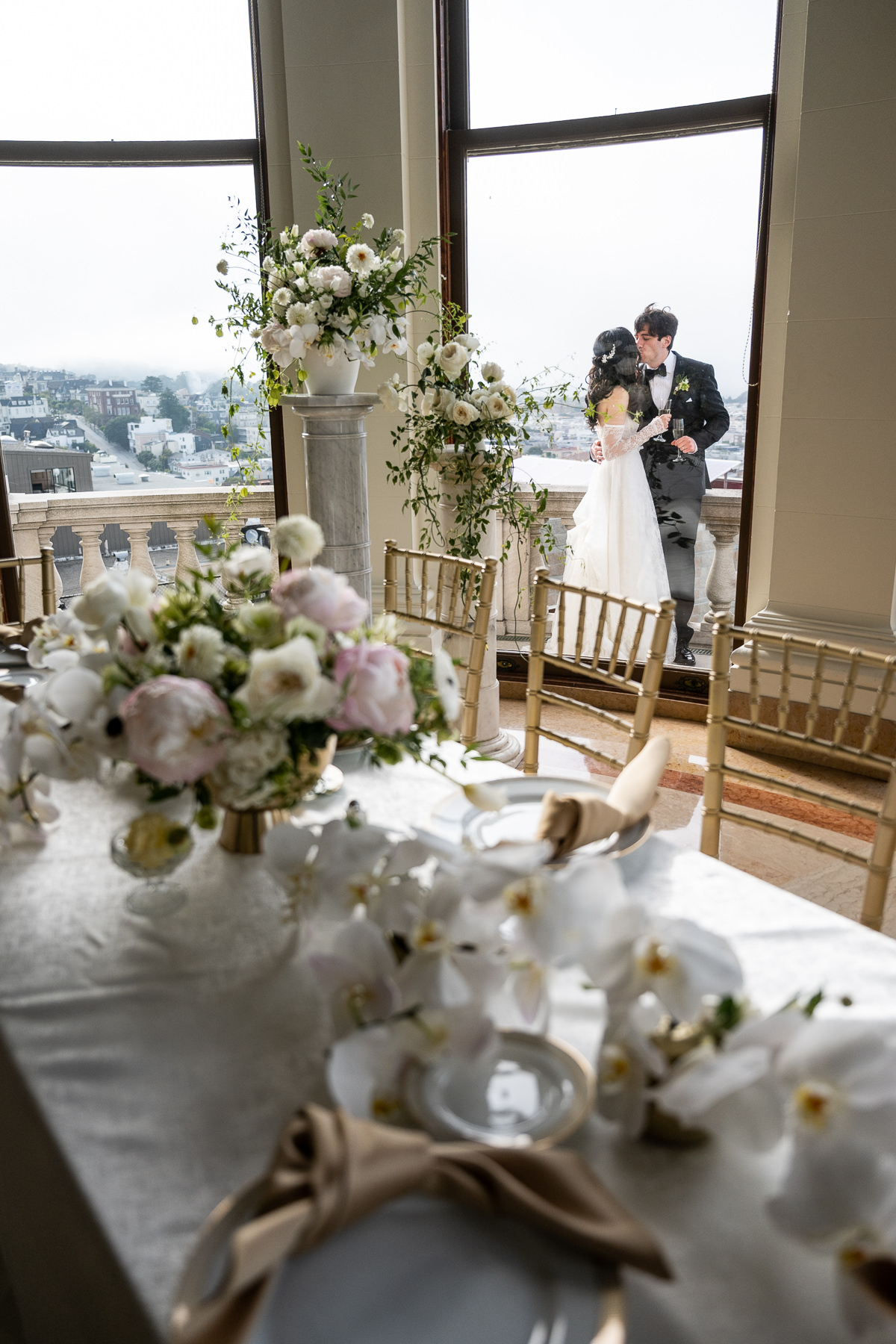 Guest giving speech at Flood Mansion reception — standing at head table in Grand Hall with guests laughing