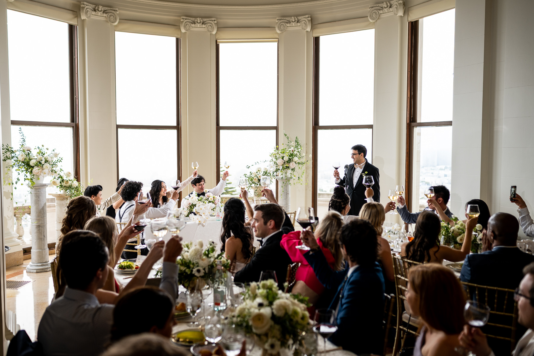 Black and white photo of bride's joyful and surprised reaction during wedding reception speeches at Flood Mansion