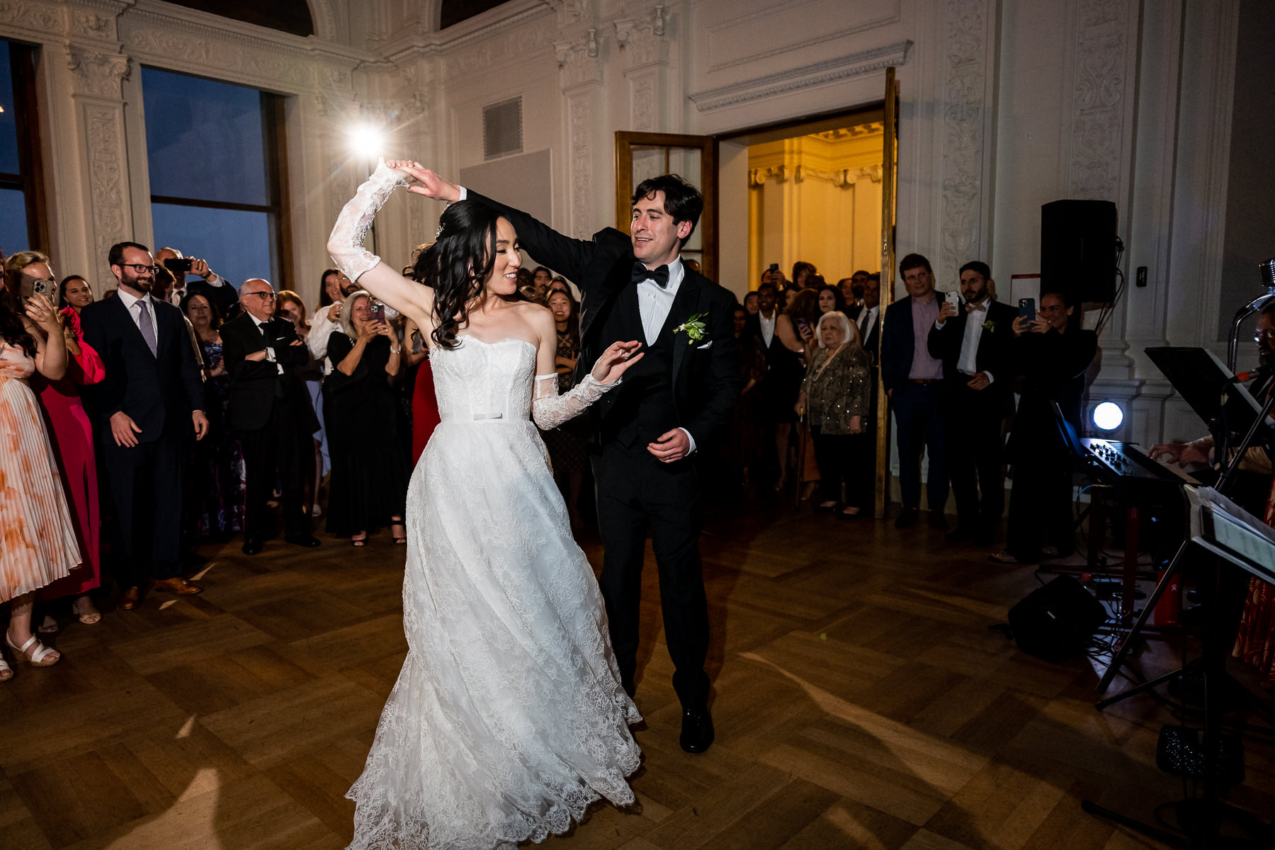 Black and white photo of bride and groom cutting wedding cake together at Flood Mansion reception, San Francisco